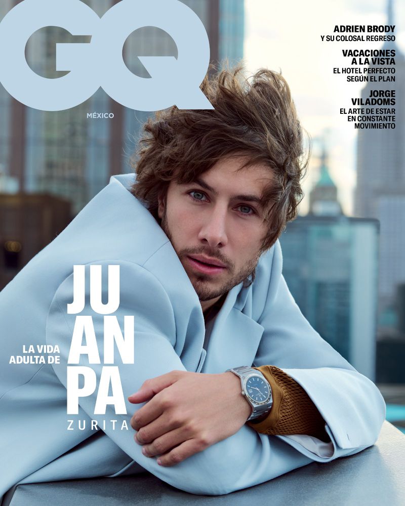 Magazine cover featuring Juanpa Zurita in a light blue blazer, posed against an urban backdrop, with the GQ Mexico logo.