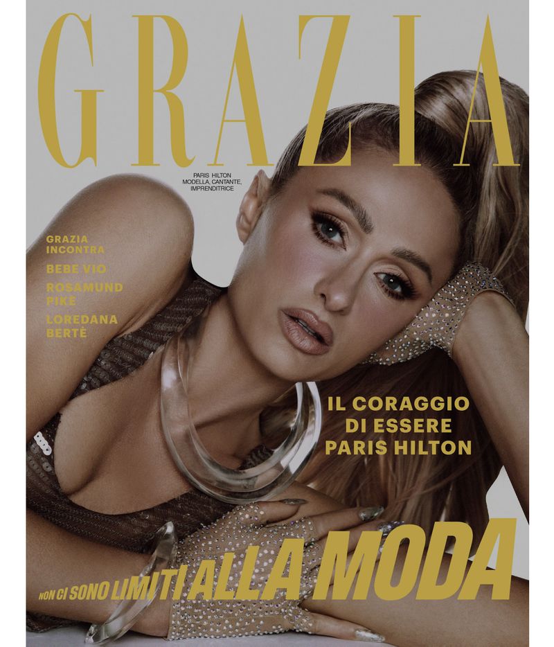 Magazine cover featuring Paris Hilton with gold text. Close-up shows her in a sparkling top and jeweled gloves against a neutral backdrop.