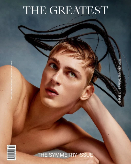 Magazine cover featuring a young adult male with light skin, blonde hair, and a distinctive headpiece against a hazy blue background.