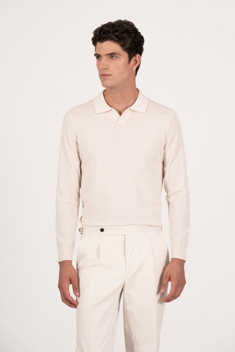 Male model wearing a cream-colored long-sleeve polo shirt and matching trousers against a plain white background