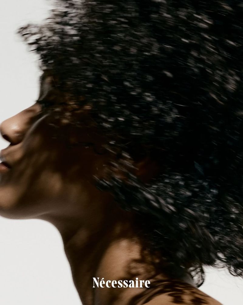 Woman with curly hair and fair skin in a beauty shot. Portrait of a model in bright, studio lighting against a clean white background.