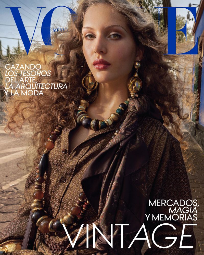 Vogue magazine cover featuring a woman with curly hair, wearing a patterned brown shirt, large earrings, and a beaded necklace.