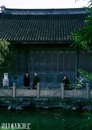 Three people stand in front of a traditional Chinese building with a pond featuring koi fish, captured in an editorial fashion shot.
