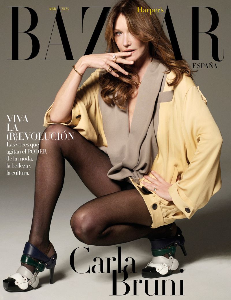 Carla Bruni poses in Harper's Bazaar España cover. She wears a yellow jacket, black tights, and platform heels. The magazine cover has the title BAZAAR.