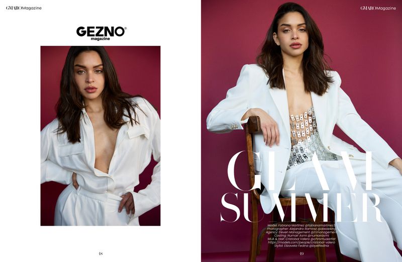 Model Fabiana Martinez in a fashion editorial for Gezno magazine, wearing a white pantsuit in front of a red studio backdrop.