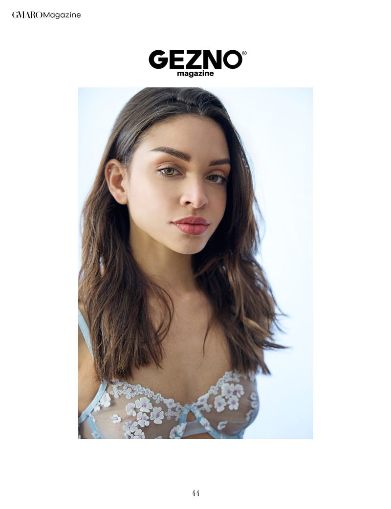 Close-up portrait of a young adult female model in lingerie with soft lighting in a photo studio setting for a fashion magazine.