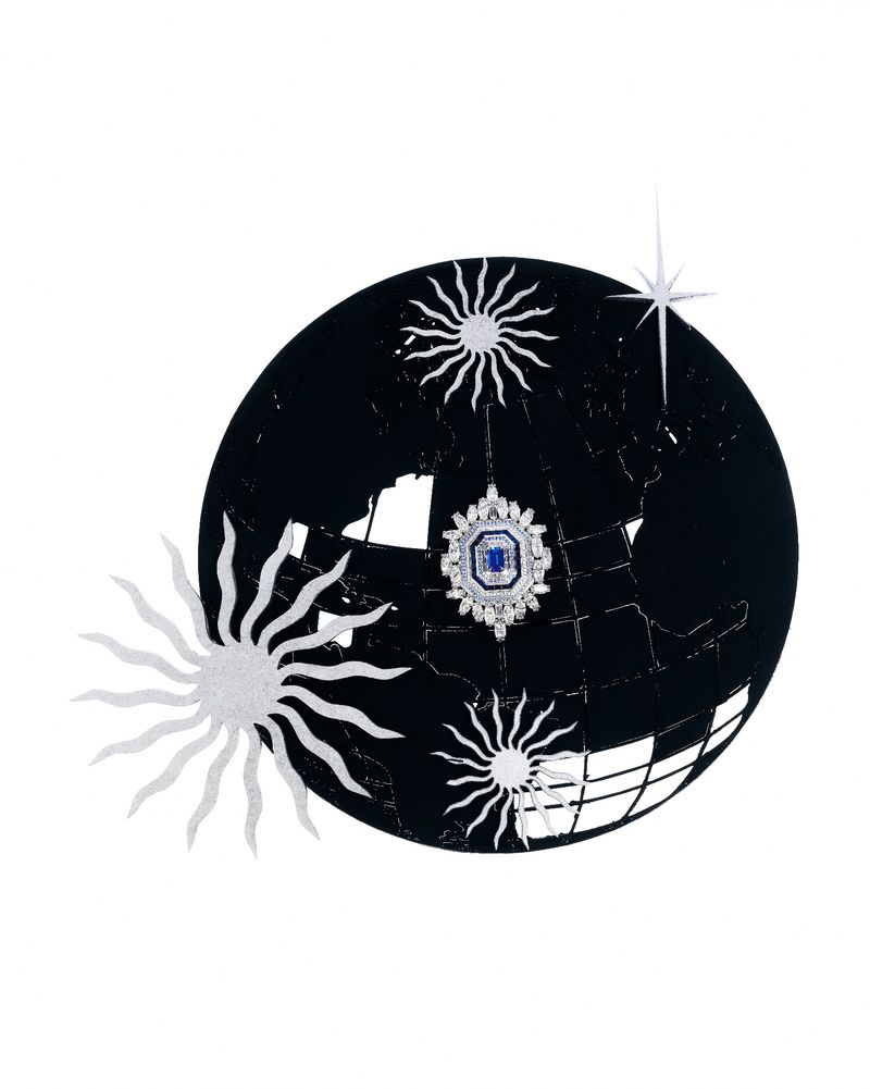 Conceptual image of a globe with sparse landmass and jeweled pendant, surrounded by radiant, sun-like burst objects on white backdrop.
