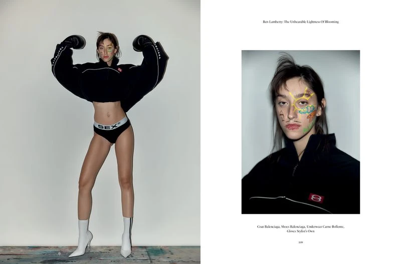 Fashion editorial shot of a slender young woman wearing boxing gloves, briefs, and boots, posing in a photo studio with soft lighting.