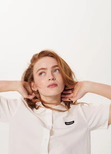 Portrait of actor Sadie Sink wearing a white collared shirt against a plain seamless white background for Elle Australia