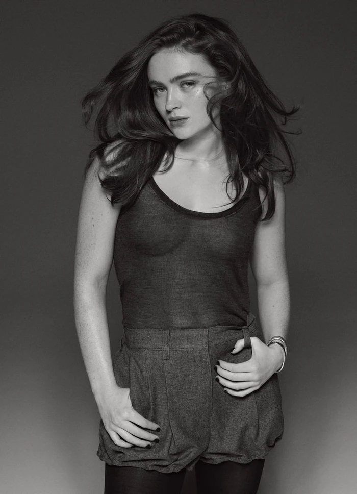 Sadie Sink in a dark tank top and shorts against a neutral studio background for Elle Australia, photographed by Philip Gay.