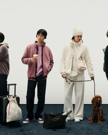 Two models posing against a white background with a dog, wearing fleece jackets for the Uniqlo F/W 25 Fleece Collection campaign.