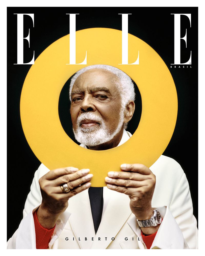 Elle Brazil magazine cover featuring Gilberto Gil holding a yellow circle, wearing a white suit and watch against a black background.