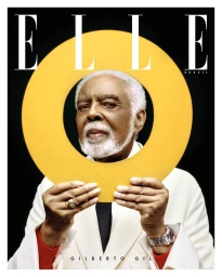 Gilberto Gil framed by a large yellow circle held up in front of his face for Elle Brasil March 2025 cover.
