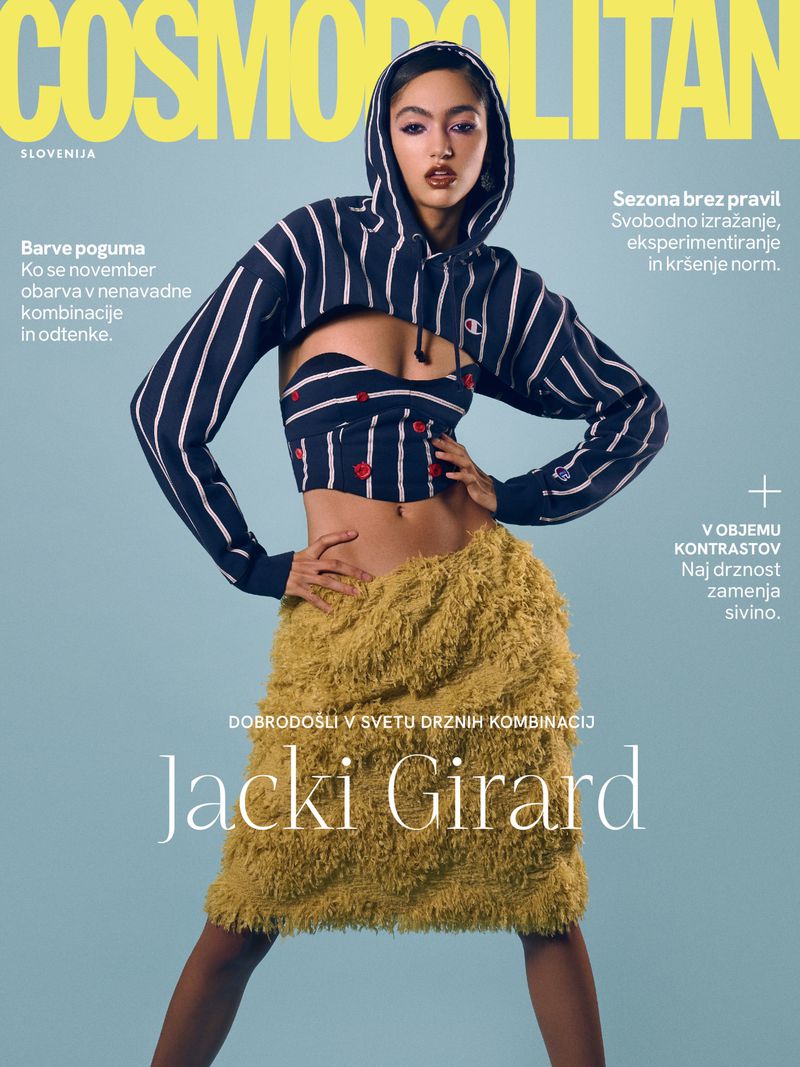 Cosmopolitan magazine cover featuring Jacki Girard in a blue striped hoodie and shaggy yellow skirt against a light blue background.