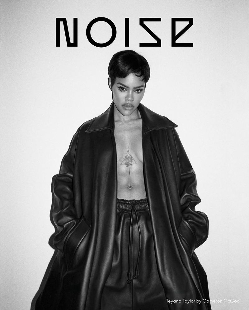 Black and white portrait of Teyana Taylor in a leather outfit against a light backdrop, showcasing fashion and celebrity style.