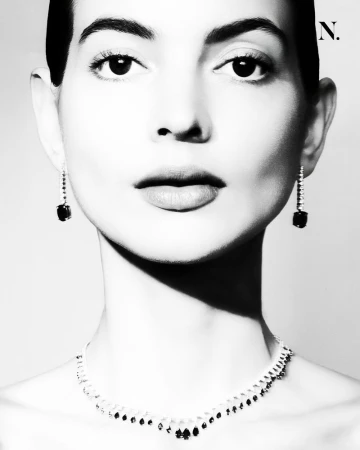 Black and white close-up portrait of model Sofia Puerta wearing a diamond collar necklace and dark gemstone drop earrings.