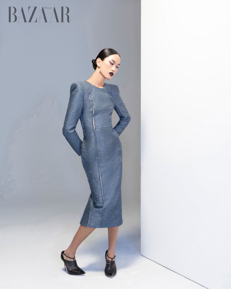 Model Parker Foubert in a fitted blue structured dress posing against a white studio background for Harper's Bazaar Vietnam.