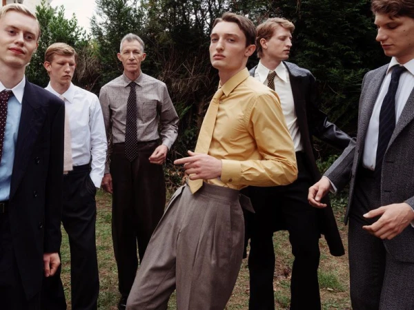 Group of six men in formal attire outdoors in a garden setting for Lampoon Magazine editorial