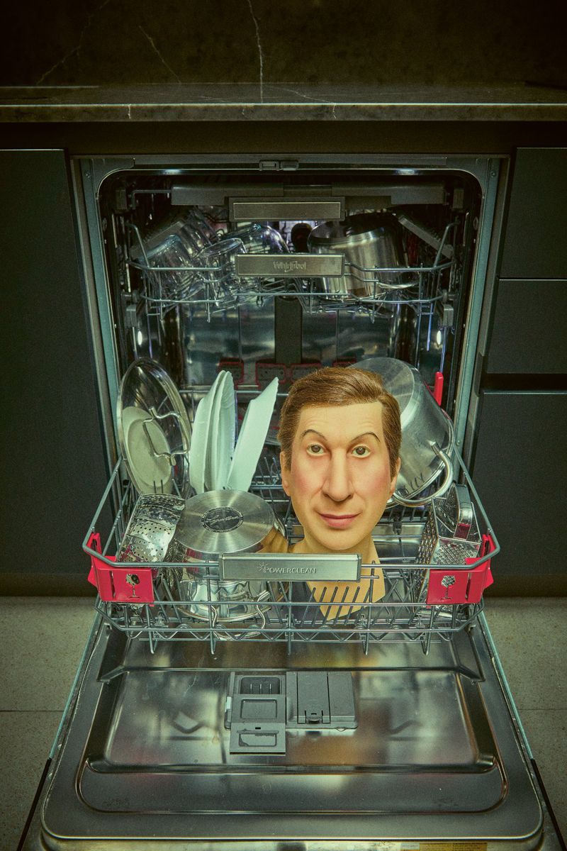 Humorous dishwasher interior showcasing a human head among dishes, creating a surreal and unexpected kitchen scene; indoor domestic appliance.