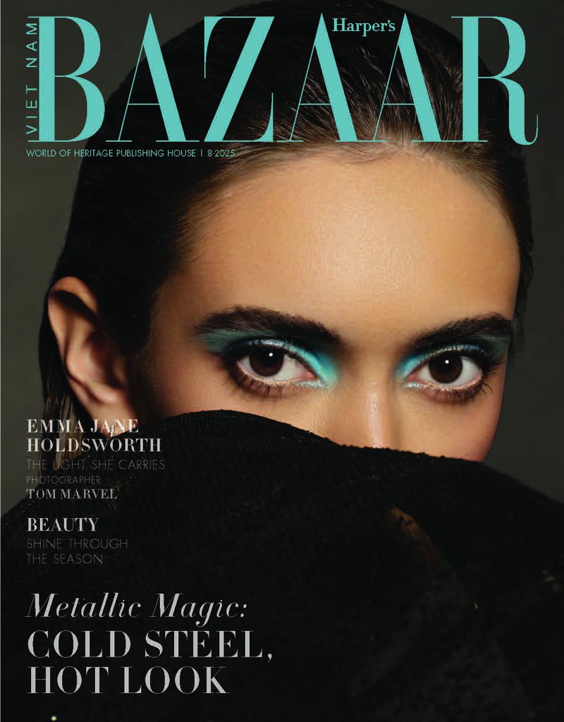Close-up fashion magazine cover featuring a woman with blue eyeshadow and black knitwear partially covering her face against a dark background.