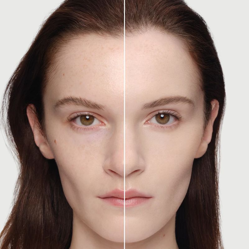 Beauty shot of a woman's face split in two: one side with foundation, the other without, neutral background, showcasing makeup.