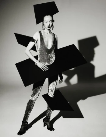 Model Fei Fei Sun poses in a shimmering bodysuit surrounded by floating black geometric rectangles in black and white.