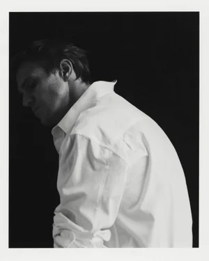 Man wearing a white shirt turned in profile against a dark background for the Minimal Trend campaign by Zara.