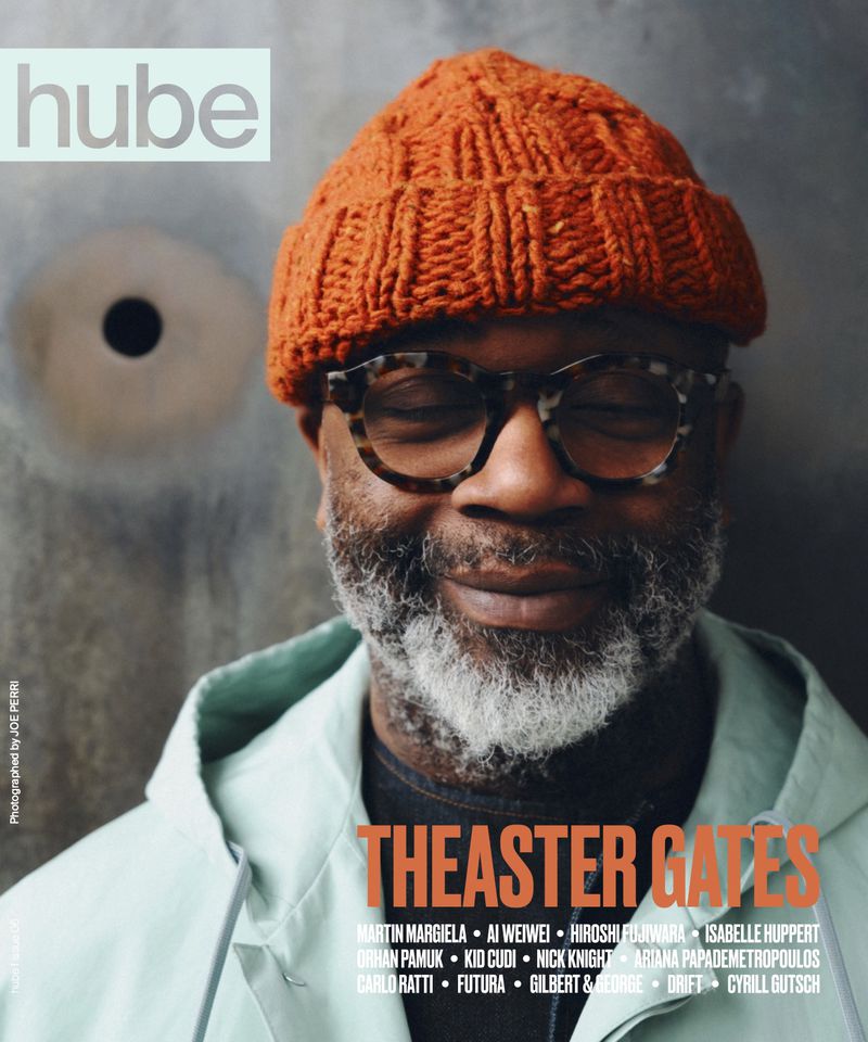 Headshot portrait of Theaster Gates wearing an orange knit hat and glasses on a magazine cover, photographed by Joe Perri.