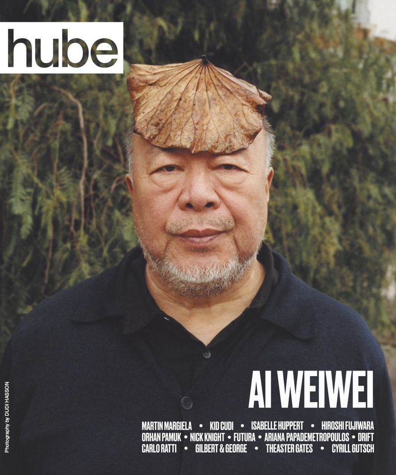 Magazine cover featuring Ai Weiwei, portrait shot. He wears a leaf on his head, has a beard, and is wearing a dark shirt.