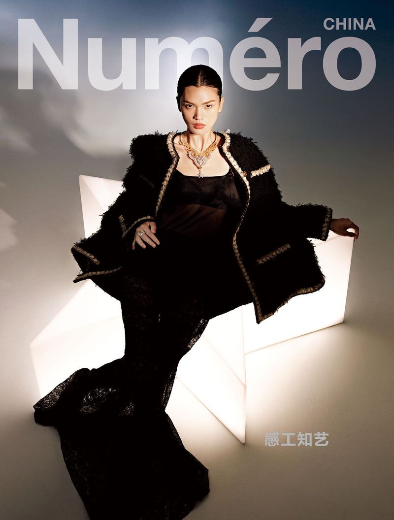 Magazine cover featuring an Asian model in a black outfit and necklace, sitting on a glowing star-shaped object against a gradient background.