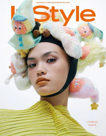 Fashion magazine cover featuring an Asian woman with avant-garde style, adorned with plush toys in a light, airy photo studio setting.