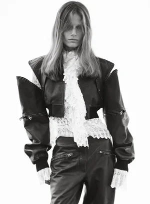 Model wearing a black leather jacket and pants with a white lace blouse against a bright background for Elle Australia by Nicole Bentley.