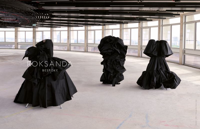 Three black dresses on display in a large, bright, modern indoor space with large windows. Fashion editorial for Roksanda Bespoke.