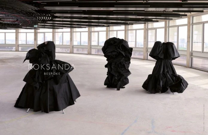 Three black dresses on display in a large, bright, modern indoor space with large windows. Fashion editorial for Roksanda Bespoke.