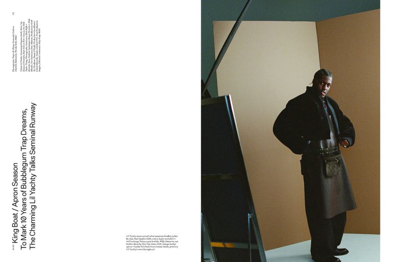 Portrait of adult male model, Lil Yachty, wearing a black jacket and leather apron in a photo studio with neutral background.