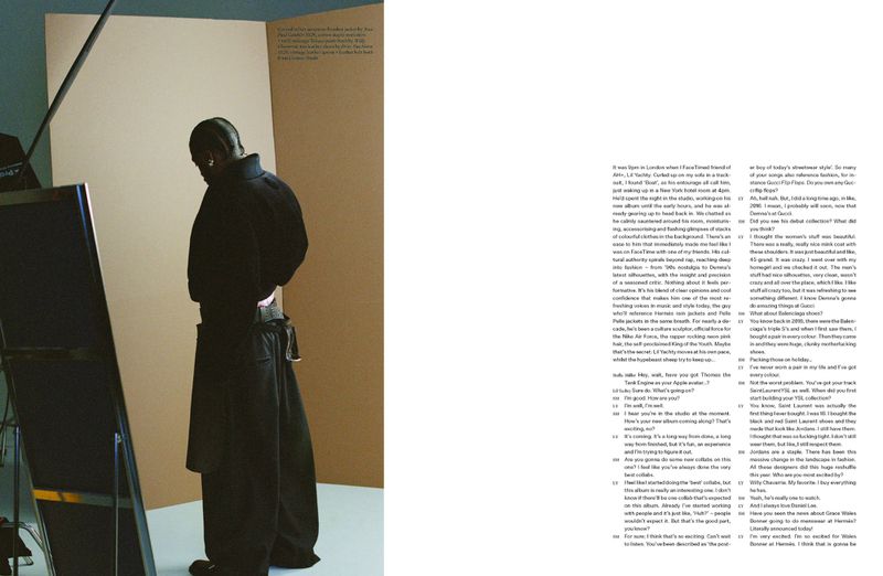 Back view of androgynous model in dark coat and pants posing in a studio, reflected in a large mirror with text visible on the right.