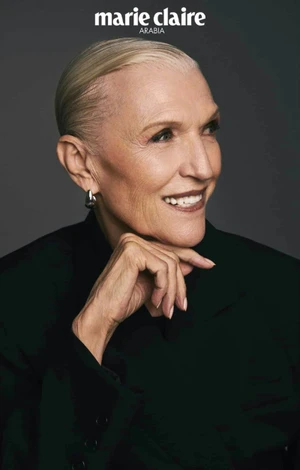 Portrait of Maye Musk with slicked-back blonde hair wearing a black jacket against a dark grey background for Marie Claire Arabia