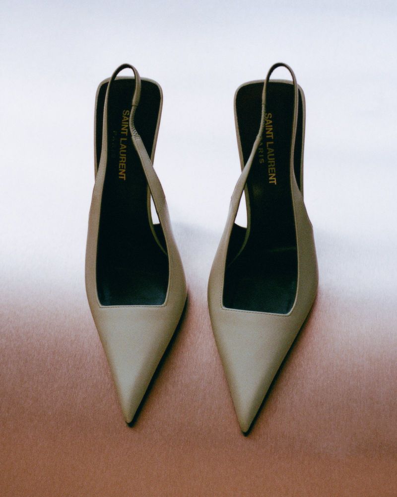 High-fashion shot of a pair of Saint Laurent slingback heels in a studio setting, showcasing elegant design and craftsmanship against soft background.