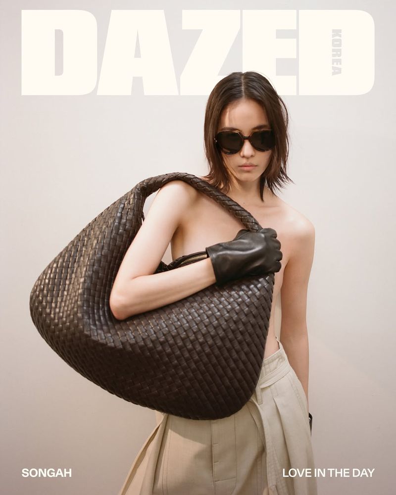 Fashion magazine cover featuring a woman with sunglasses and a large woven bag, styled with gloves and a neutral skirt against a plain backdrop.