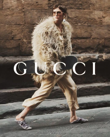 Fashion photo of a woman in a fur coat and sunglasses, holding a skateboard in front of a building with the Gucci logo overlaid.