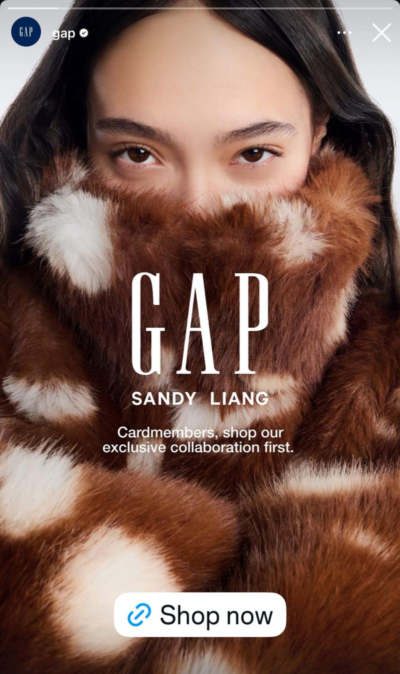 Fashion ad for GAP featuring a model wearing a faux fur coat with brown and white spots, partially covering her face, with the GAP logo.