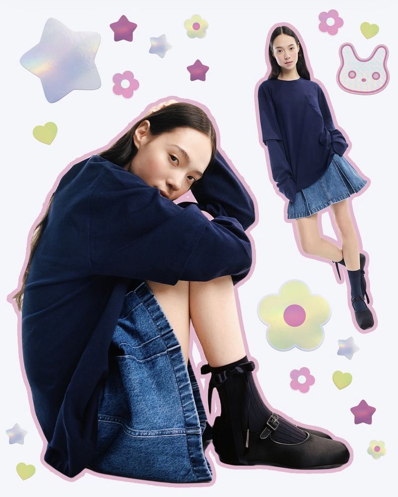 Two young women pose in navy tops and denim skirts with holographic flower stickers on a light background in a fashion-style image.