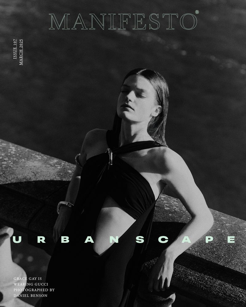 Monochrome magazine cover portrait of a female model leaning against a stone structure outdoors.
