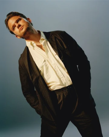 Jeremy Irvine wearing a dark suit jacket and white shirt against a neutral background for Cero Magazine.