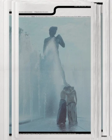 Two shirtless men standing in a fountain, with a tall sculpture of a man in the background, depicted on a printed media cover.
