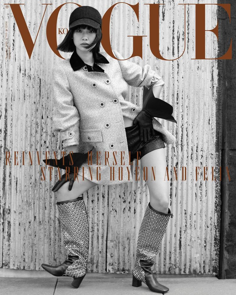 Vogue Korea cover featuring a stylish woman in a tweed coat, shorts, and boots, posing against a textured metal wall with neutral tones.
