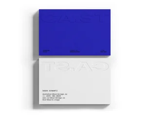 Two stacked business cards in royal blue and clean white featuring embossed typography for Cardboard Stage.