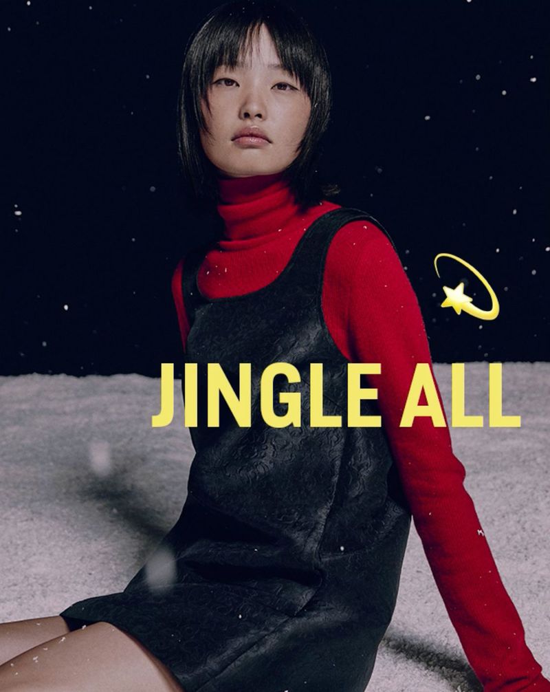 Asian woman in a black dress with a red turtleneck in a studio setting with snow and graphic star. Fashion editorial shot.