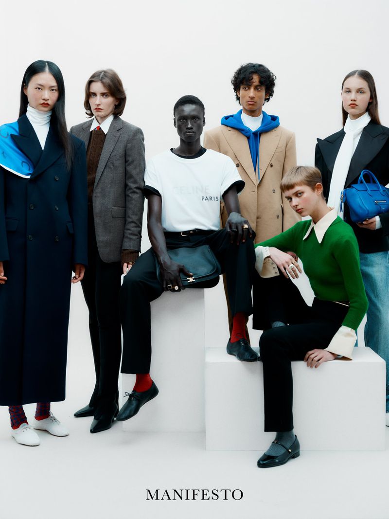 Six fashion models in a studio pose together, showcasing a variety of styles, including tailored jackets, sweaters, and casual tops.