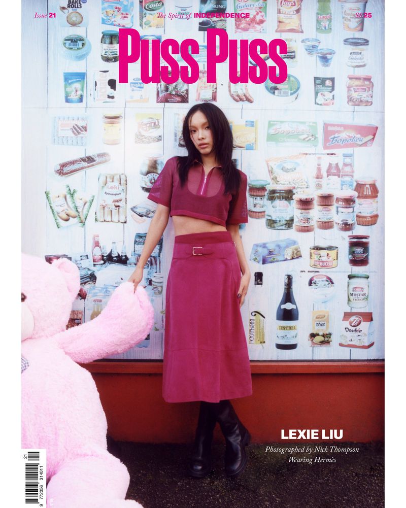 Lexie Liu poses in a magazine cover against a wall of food products, wearing a magenta top, skirt, and black boots, with a pink teddy bear.